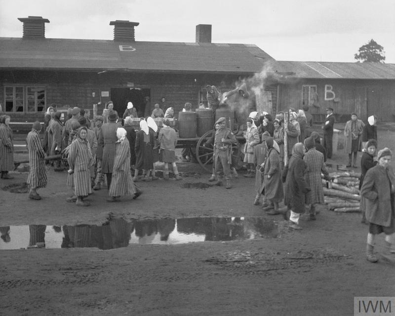 British soldiers supervise the distribution of food to camp inmates, April 1945