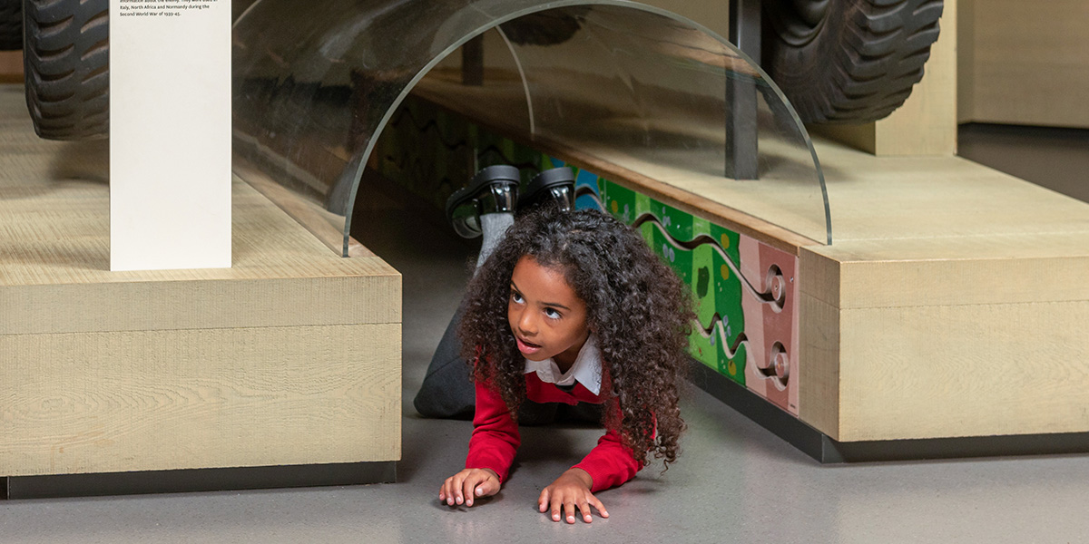 A child crawling under the Dingo Scout Car
