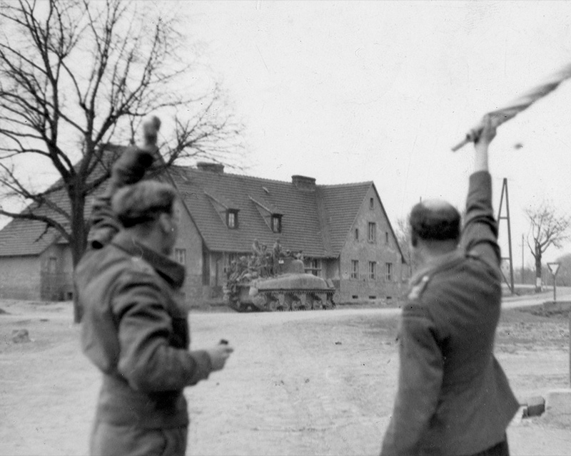 Officers greeting troops aboard a tank, April 1945